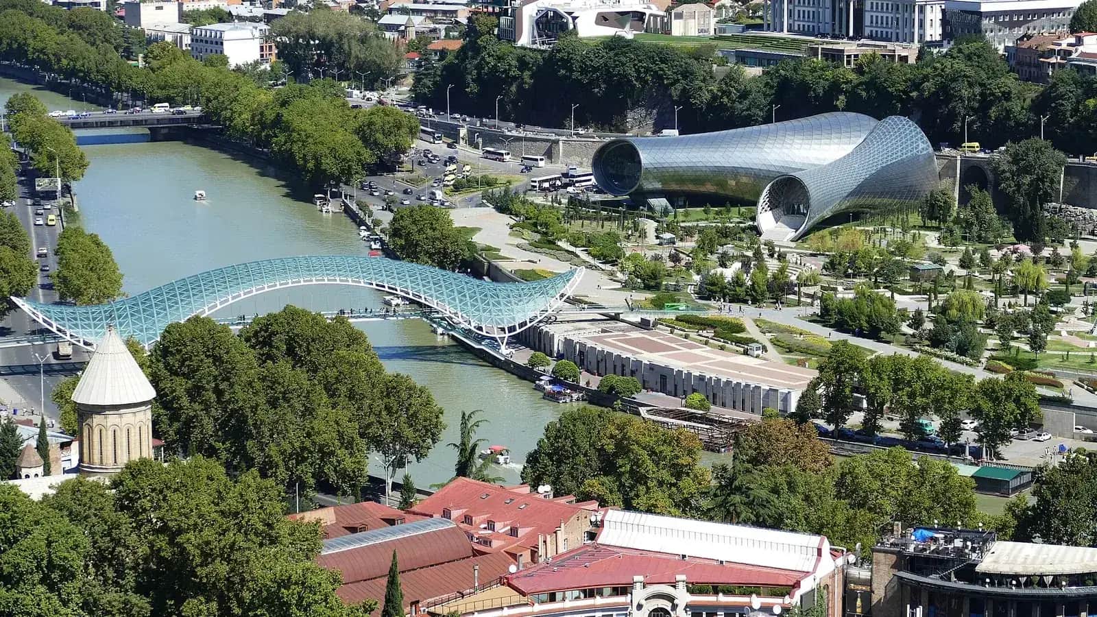 Vue plongeante sur la Koura à Tbilissi, avec le Pont de la Paix en verre et acier et le parc Rike