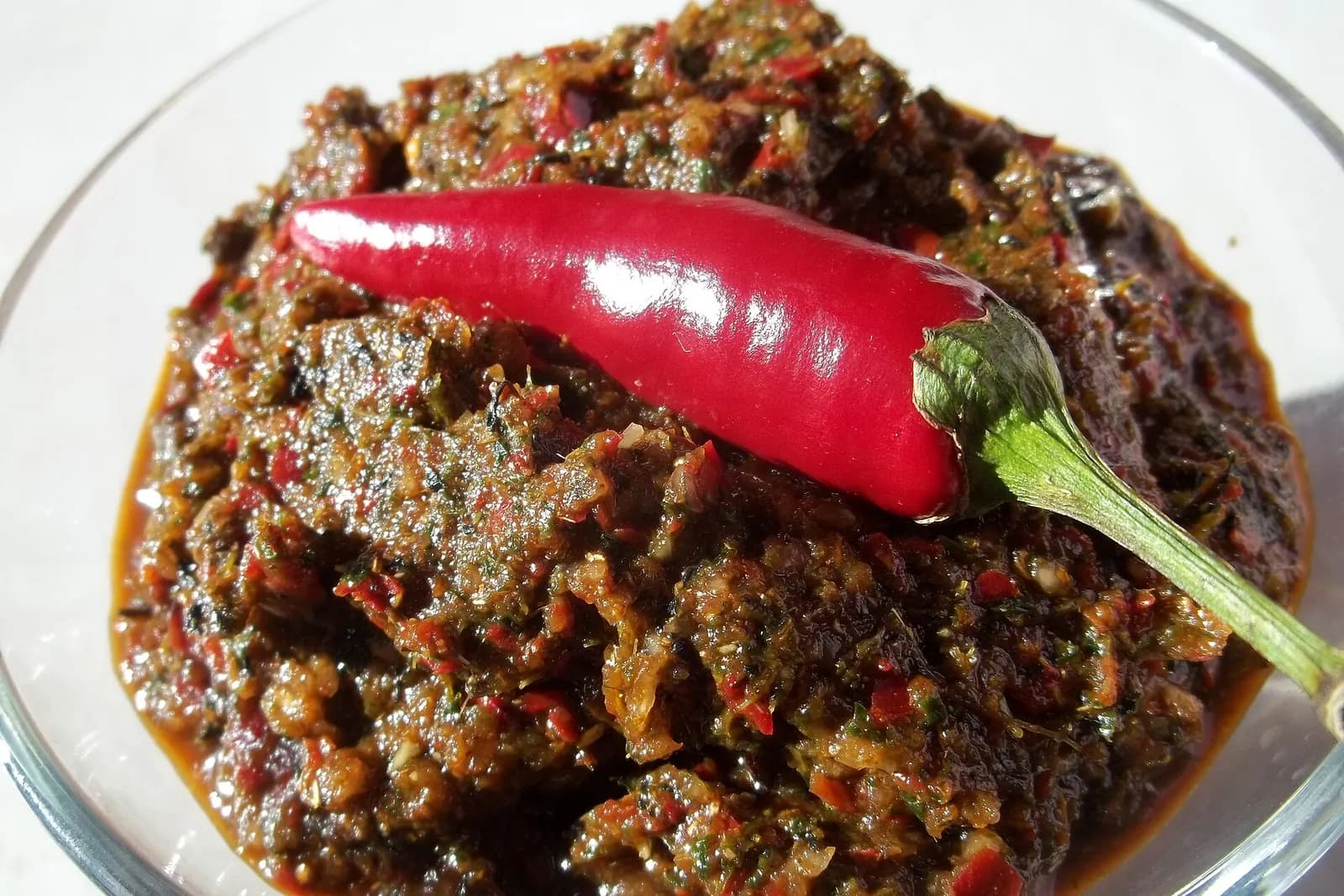 Adjika mingrélienne, pâte épicée de piments rouges, d'ail et d'herbes, surmontée d'un piment frais