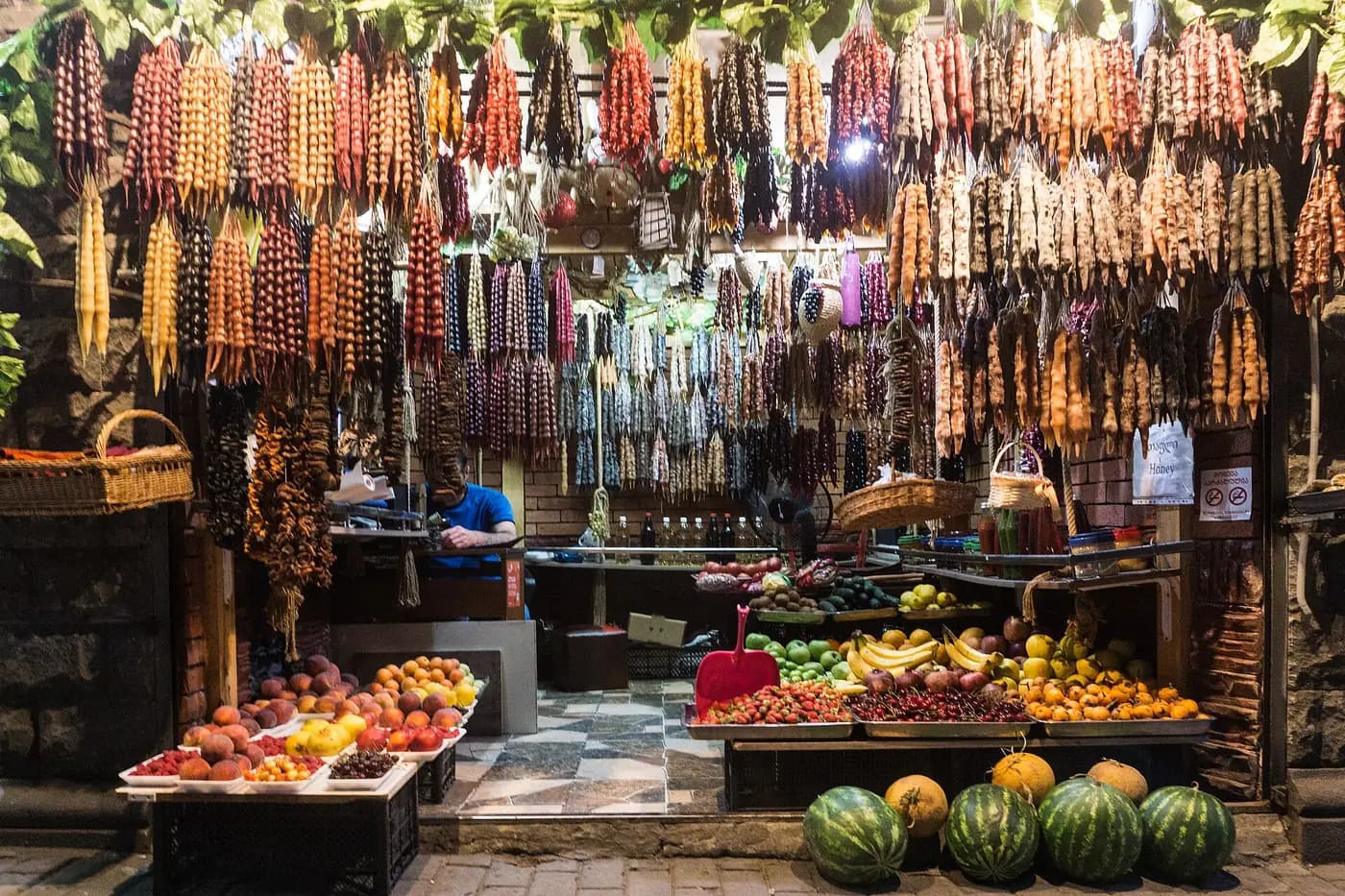 Boutique de Tbilissi aux churchkhelas suspendues en grappes, avec pêches, abricots, cerises, fraises et pastèques à l'étal