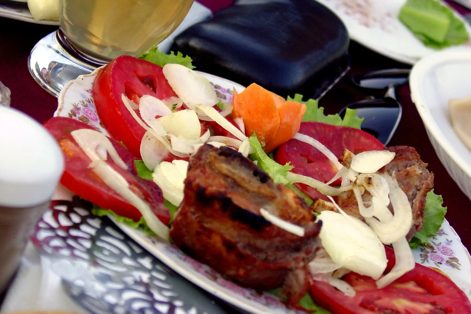 Mtsvadi, brochettes de viande grillée servies avec tomates, oignons et laitue sur une assiette décorée