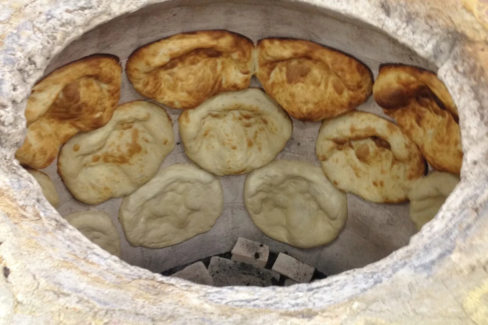 Pains géorgiens cuits contre la paroi intérieure d'un four tone en argile