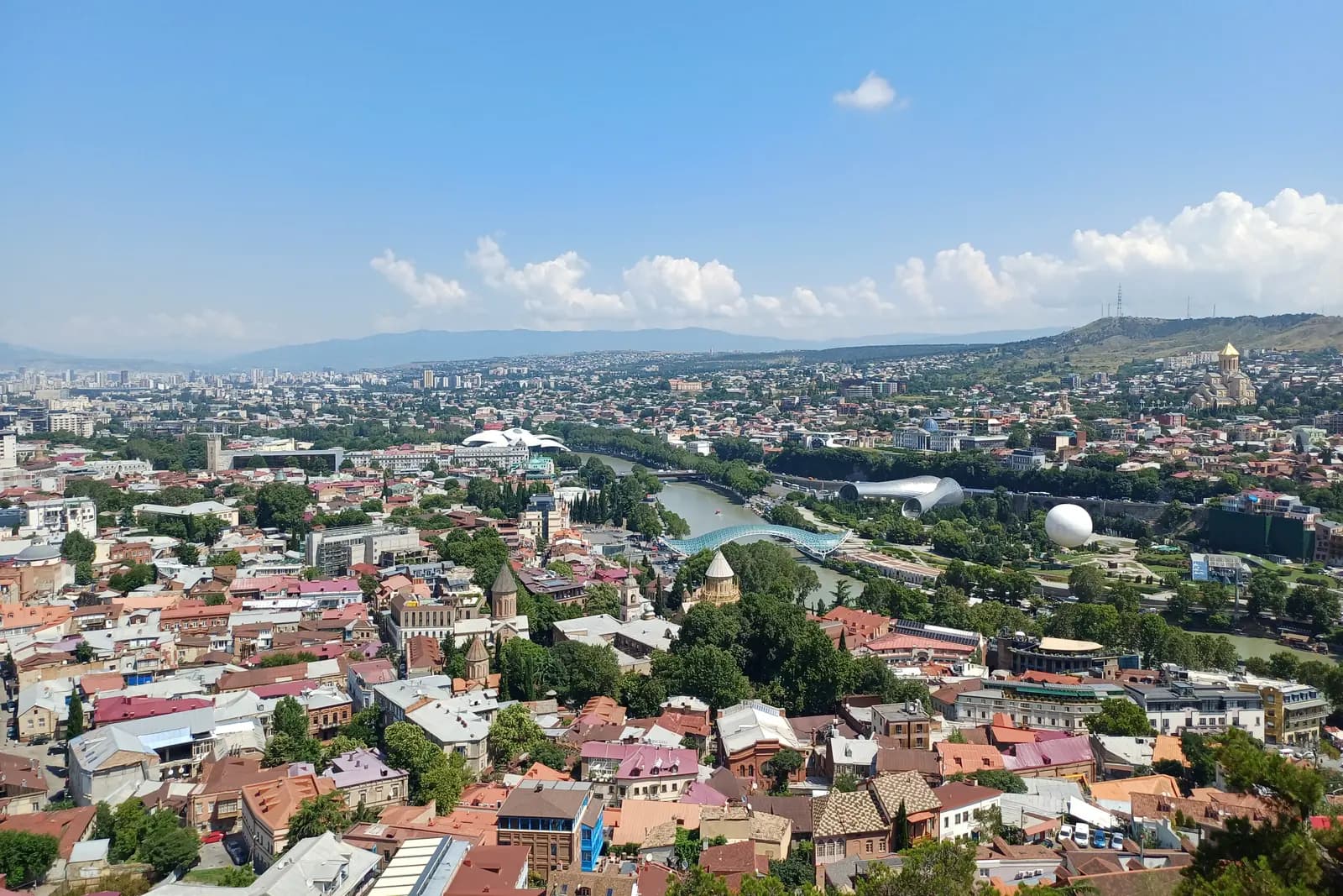 Vue de Tbilissi depuis les hauteurs de Sololaki : toits de la vieille ville, pont de la Paix sur la Koura et quartiers résidentiels à l’horizon