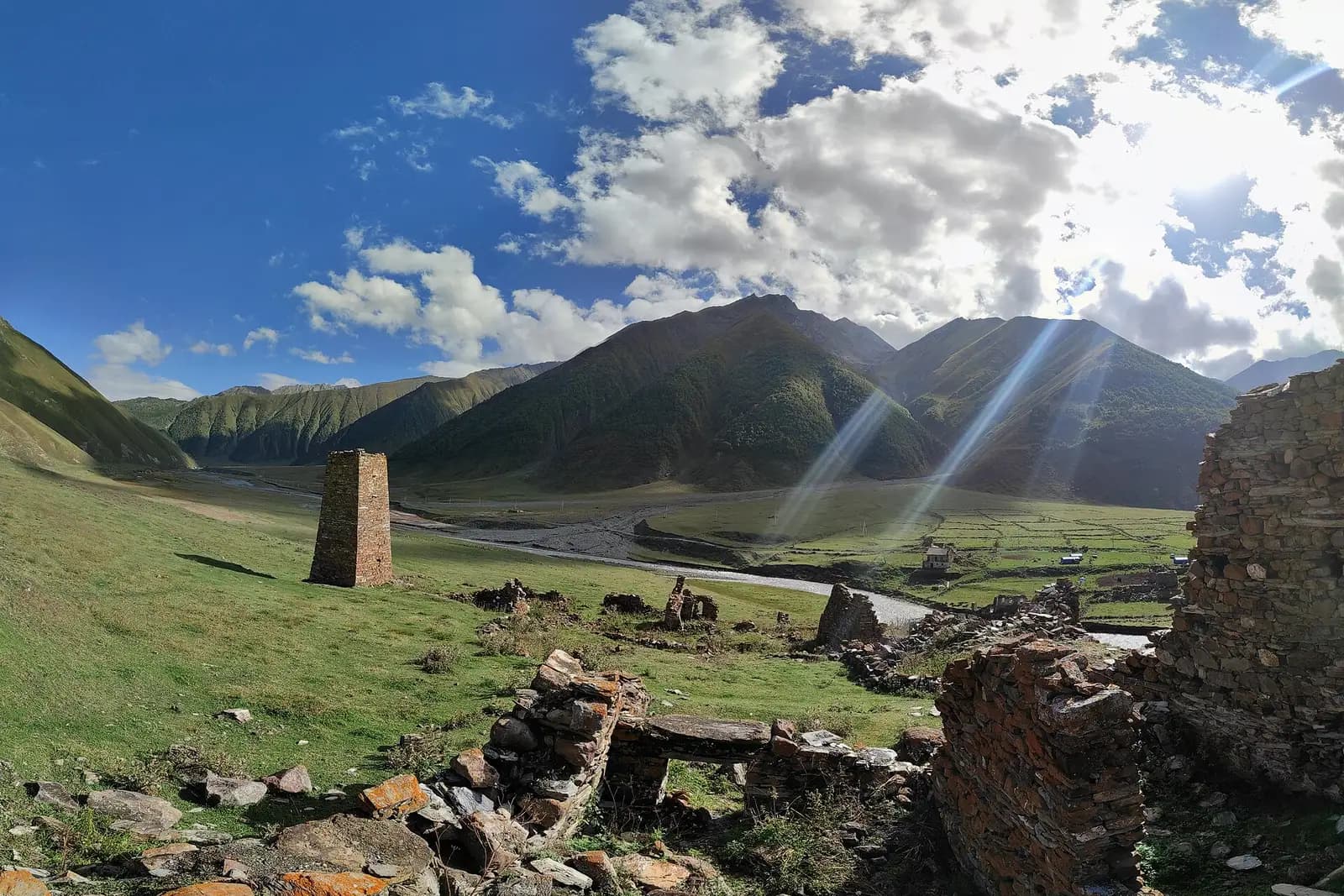 Tour de pierre et ruines dans la vallée de Truso, avec la rivière Terek et les montagnes du Grand Caucase
