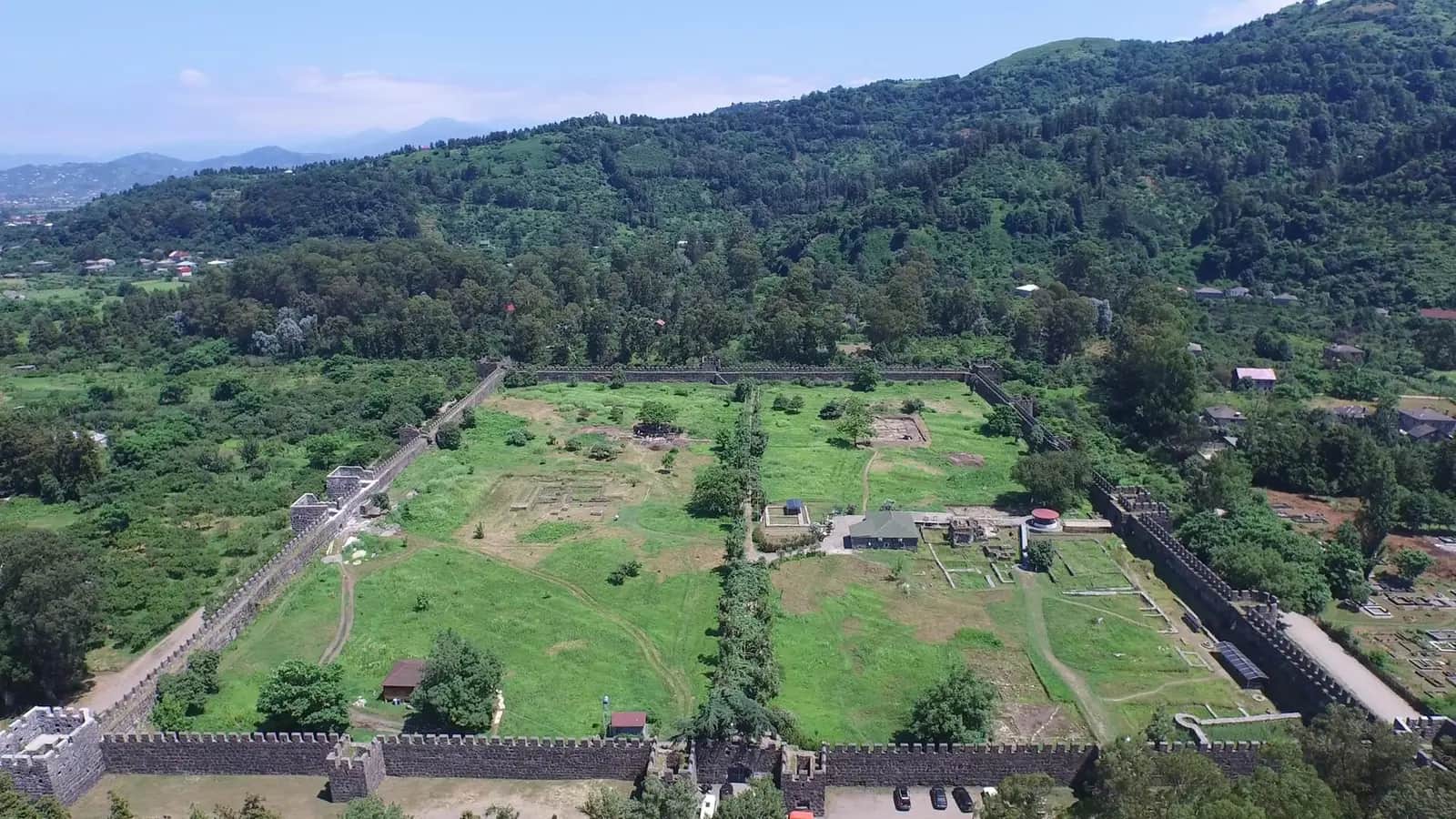 Vue aérienne de la forteresse de Gonio-Apsaros, enceinte de pierre et remparts crénelés au pied des collines boisées d'Adjarie