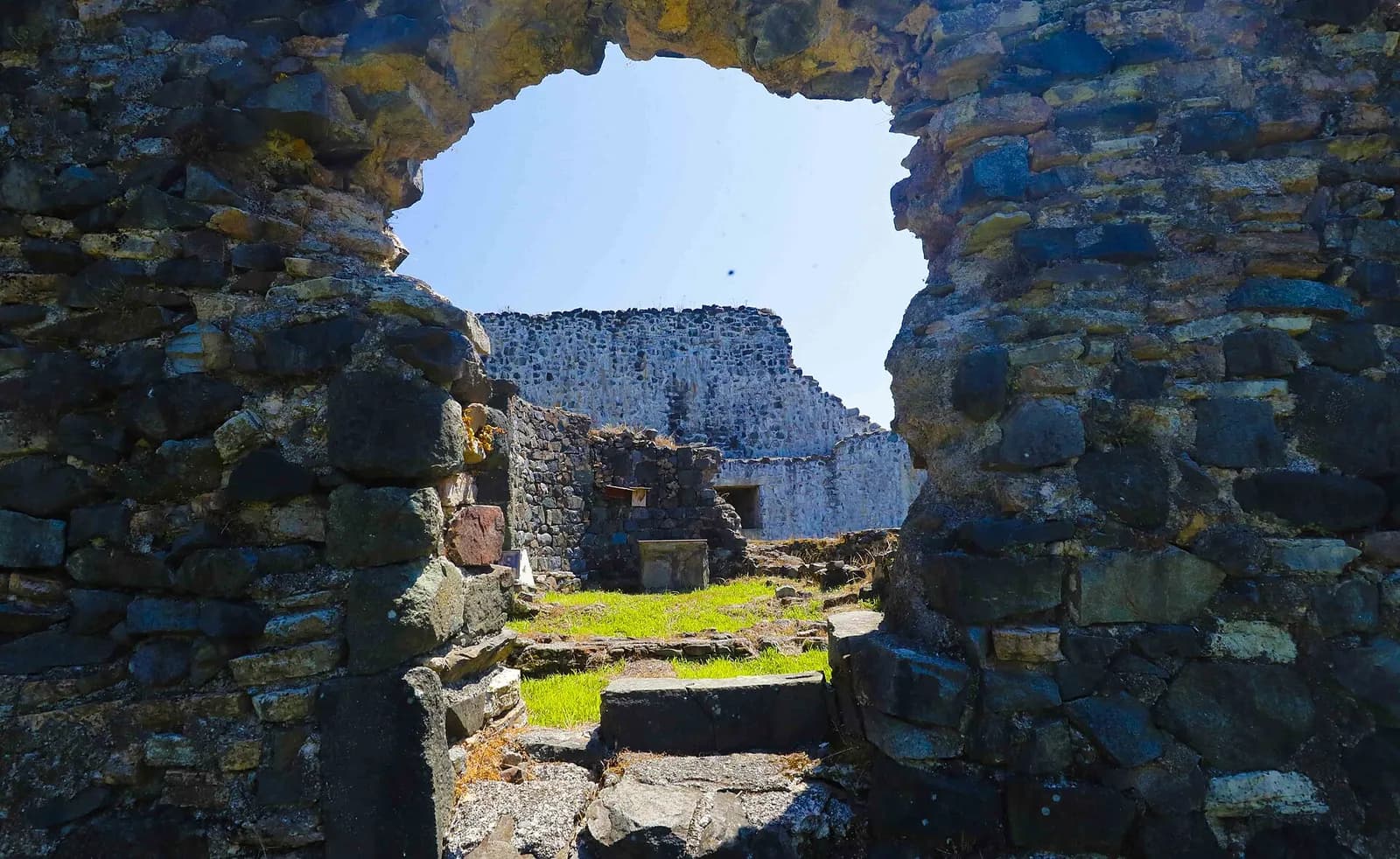 Ruines de la forteresse de Petra à Tsikhisdziri, murs de pierre et pelouse vue à travers une brèche