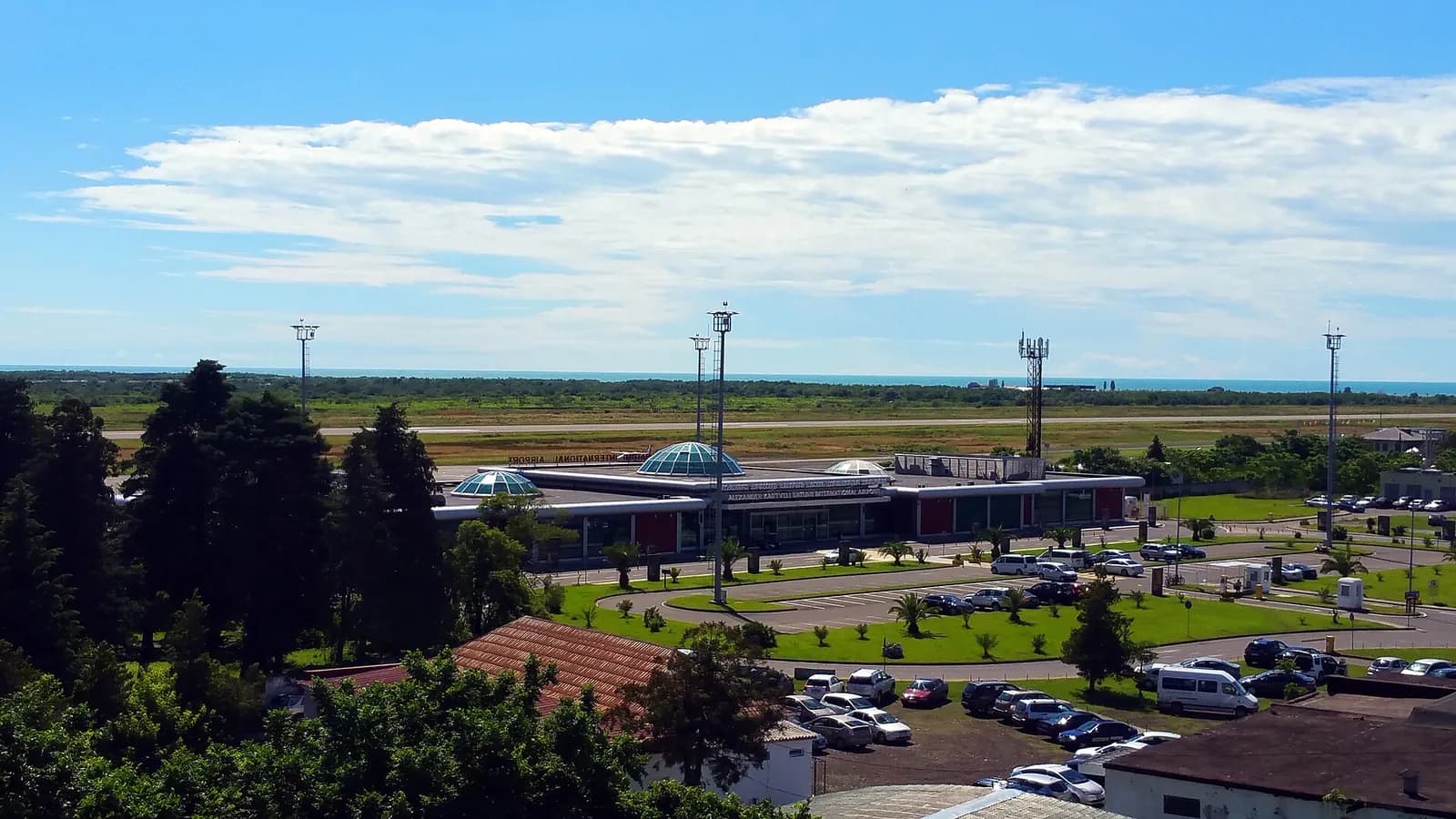 Terminal de l'aéroport international de Batoumi vu de haut, avec la piste et la mer Noire à l'horizon