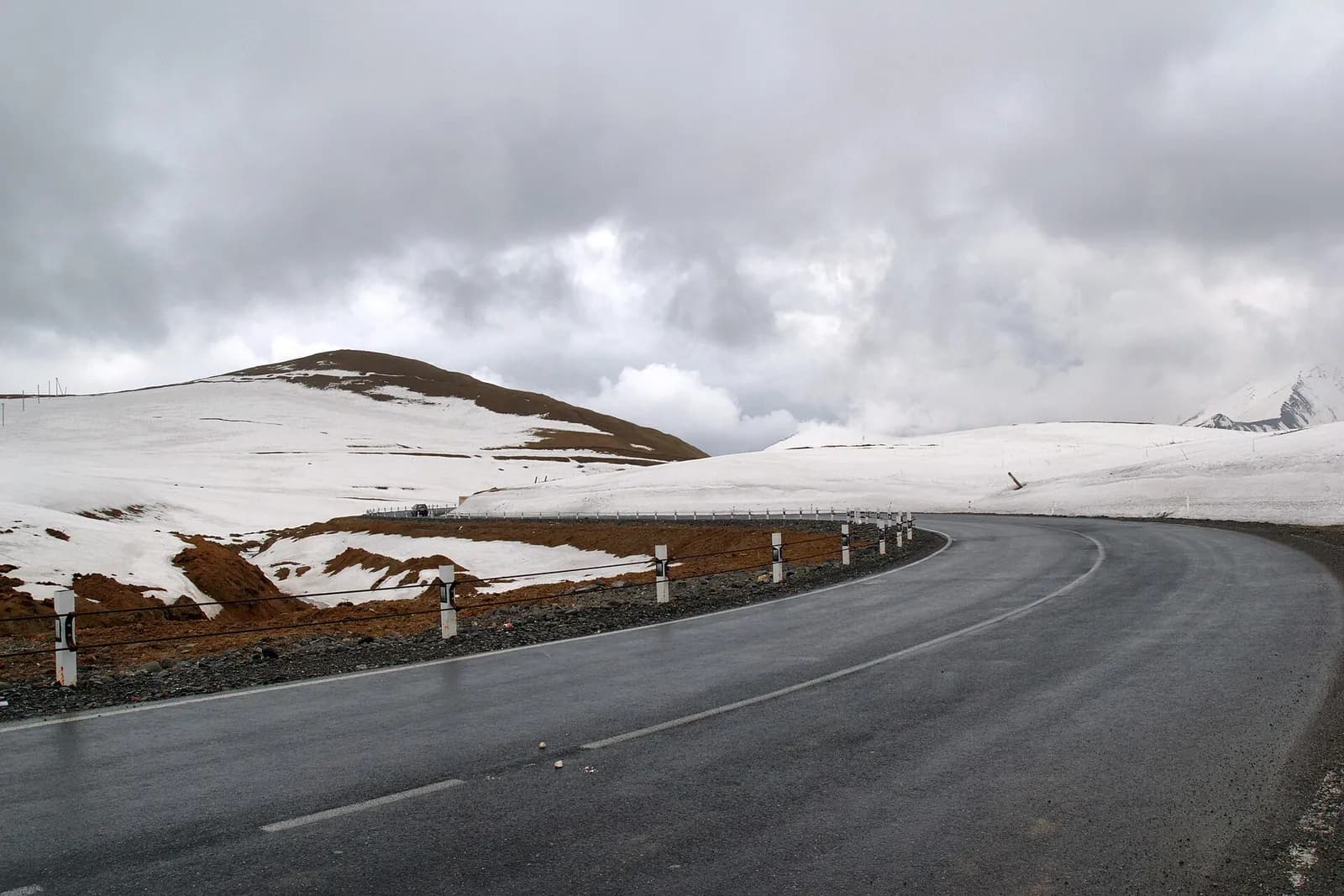 Route asphaltée en lacet sur un col enneigé de la route militaire géorgienne