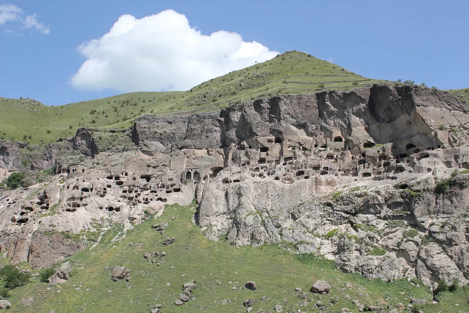 Vue d'ensemble de la falaise de Vardzia, ses galeries et ses ouvertures creusées dans le tuf au-dessus de la Koura