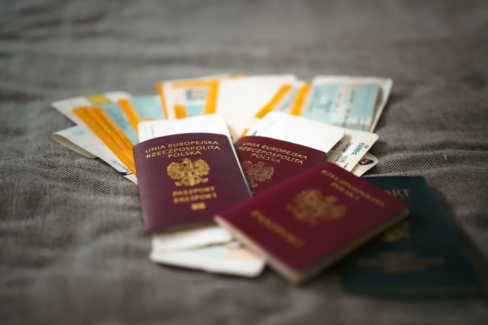 Passeports et titres de transport posés en vrac sur un tissu gris